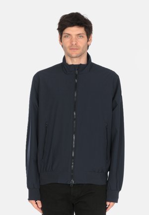 Donkerblauwe lichtgewicht jas met een staande kraag, voorkeursrits en twee ritszakken. Heeft elastische manchetten en een tailleband voor een getailleerde look.