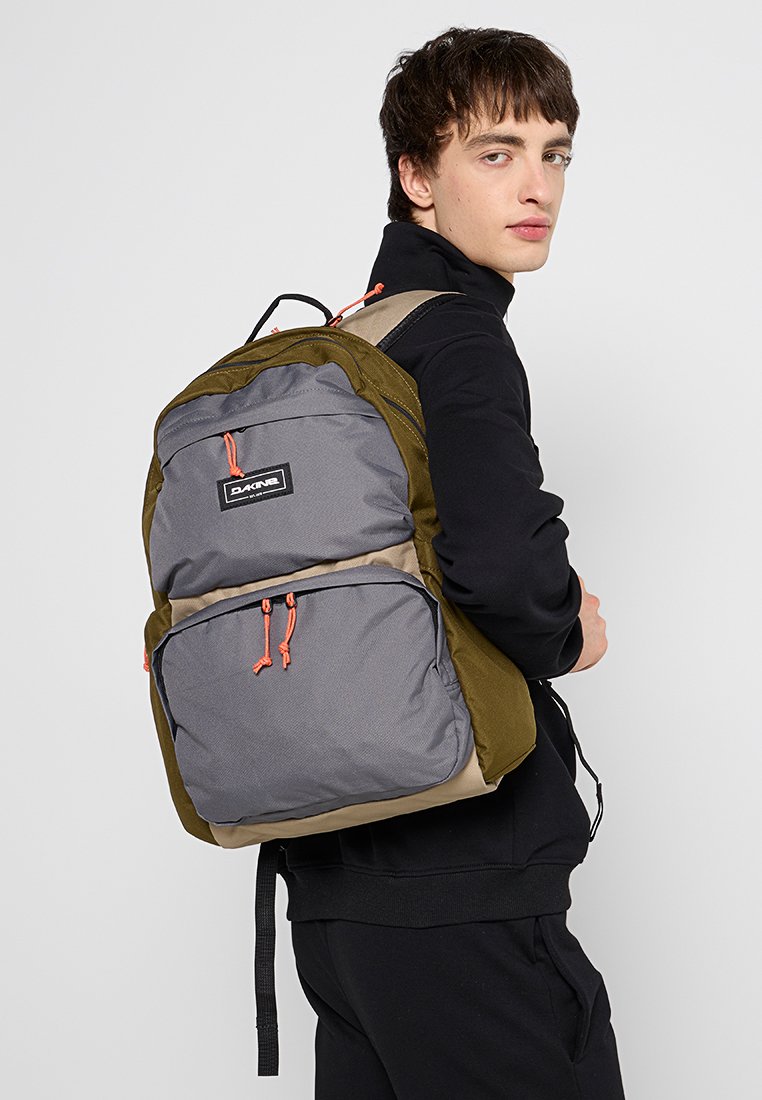 Dunkelgrüner und grauer Stoff-Rucksack mit orangefarbenen Akzenten, ausgestattet mit mehreren Reißverschlusstaschen und einem gepolsterten Rücken für Komfort.