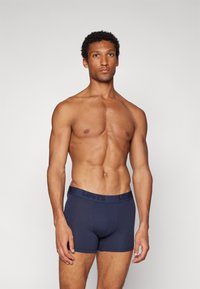 Marineblaue Boxershorts aus weichem Material mit einem breiten, geprägten Levi's Bund. Das formschlüssige Design verbessert den Komfort und die Unterstützung.