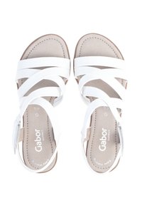 Valkoiset nahka-sandaalit, joissa on ristikkäiset strapsit, litteä pohja ja beige varvasosa. Sisäpohjassa Gabor-logomerkintä.