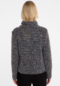 Strickpullover in Grau und Schwarz mit Struktur und hohem Kragen, im lässigen Schnitt aus weichem, dickem Garn.