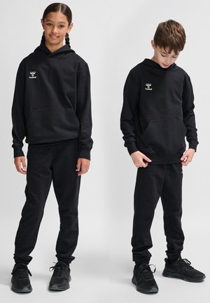 Felpa con cappuccio nera e pantaloni jogger coordinati realizzati in un tessuto morbido. Presenta una tasca frontale e un logo sul petto. Indossati con scarpe da ginnastica nere.