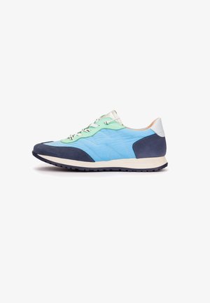 Zapatilla baja con tejido acolchado azul claro, superposiciones de ante azul marino, detalles en verde menta, cordones blancos y suela crema sobre fondo blanco.