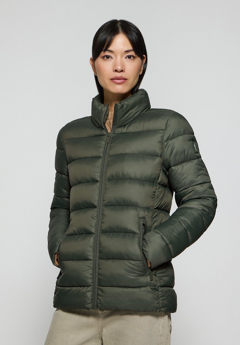 Grön puffjacka med hög krage, dragkedja fram och kviltad design. Tillverkad av ett slätt, glänsande tyg med sidfickor.