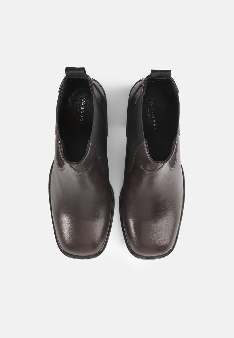 Stivali in pelle marrone con punte rotonde, pannelli laterali elastici e linguette di trazione. Finitura liscia con una leggera lucentezza, su uno sfondo bianco semplice.