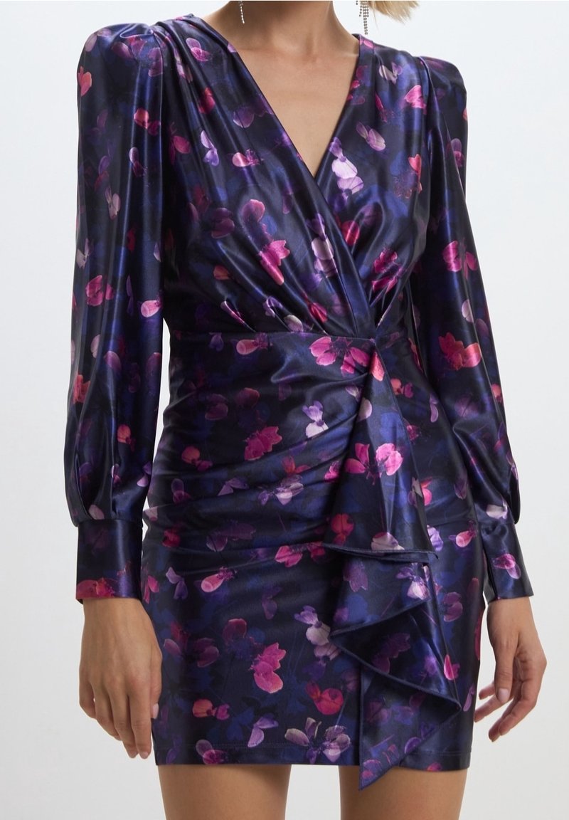 Robe portefeuille bleu marine brillante avec de longues manches bouffantes et un imprimé floral rose-violet, avec un détail de volants drapés sur la jupe avant.
