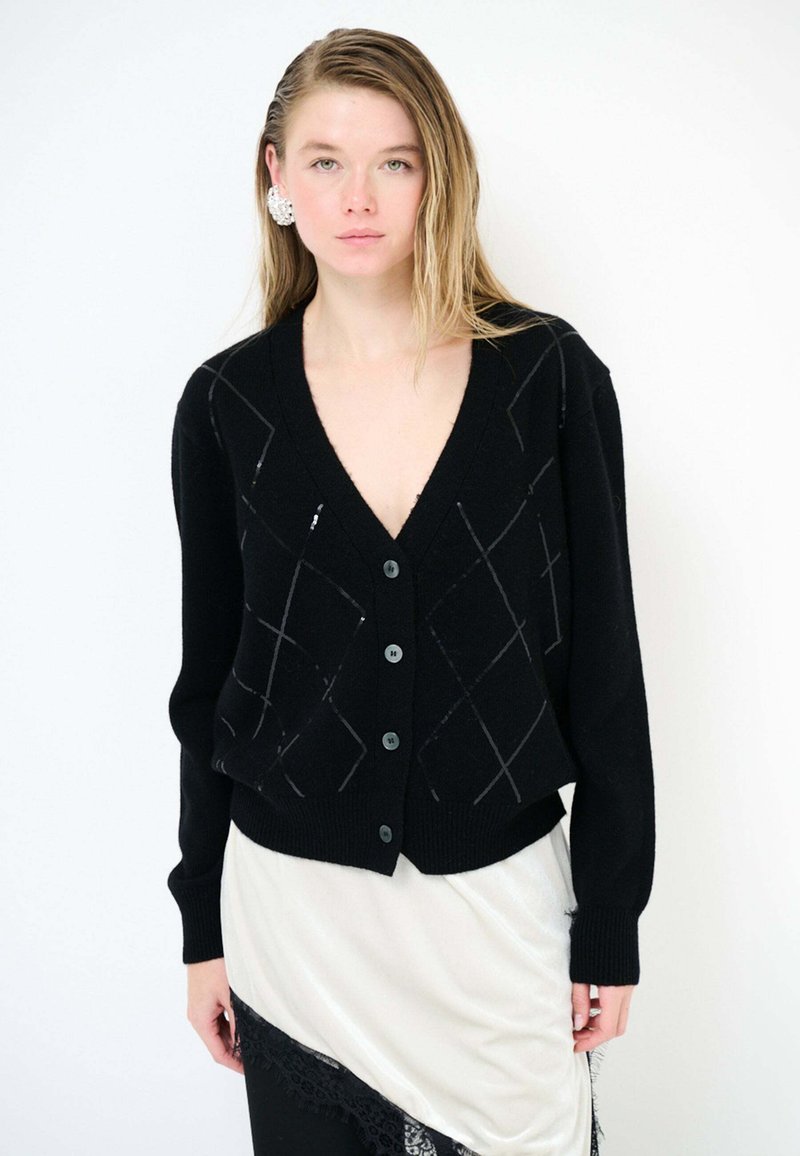 Cardigan nero lavorato a maglia con scollo a V, caratterizzato da un motivo a diamante in grigio. Ha cinque bottoni neri, polsini a coste e una vestibilità ampia.