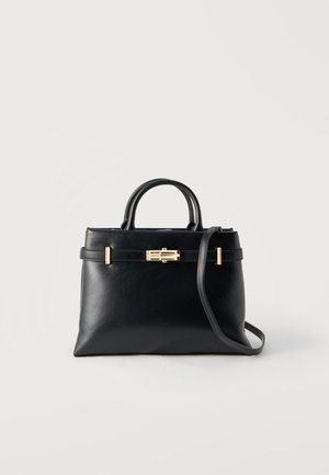 Schwarze Lederhandtasche mit doppelten Griffen, einem goldenen rechteckigen Verschluss und einem abnehmbaren Schulterriemen vor weißem Hintergrund.