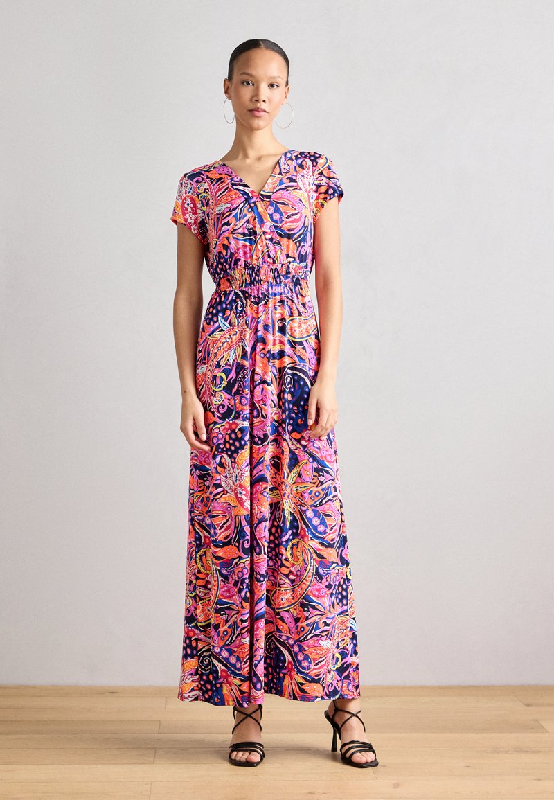 Robe maxi avec un motif floral coloré, manches courtes, taille élastique et tissu fluide. Présente des teintes vibrantes de rose, bleu et orange.