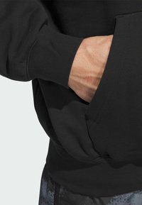 Sort sweatshirt med en kænguro-lomme. Har ribbede manchetter og kant, glat tekstur og en afslappet, casual pasform.