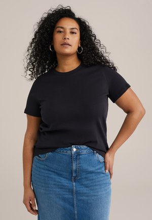 Camiseta negra de manga corta hecha de tela suave, combinada con una falda de mezclilla azul. La camiseta tiene un escote redondo y un corte relajado.