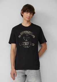 Zwarte katoenen t-shirt met korte mouwen en een ronde hals, met een verouderde lichtgekleurde grafische print aan de voorkant.