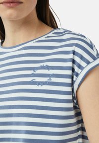 T-shirt rayé en coton bleu et blanc avec des manches courtes retroussées, présentant un graphique circulaire avec l'inscription "OH HEY VACAY" à l'avant.