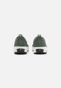 Zielone siatkowe sneakersy z białą podeszwą i czarną gumową podeszwą antypoślizgową, z pętelką na pięcie ułatwiającą zakładanie.