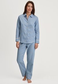 Set di pigiama a quadretti blu e bianchi con una camicia con bottoni e pantaloni dritti, caratterizzato da un colletto classico e polsini.
