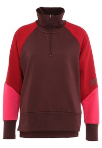 Sudadera de cuello con cremallera en color marrón y rojo con acentos rosas, presenta un ajuste relajado, mangas raglán y la palabra "JUST" impresa en una manga.