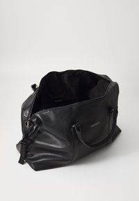 Black leather tote bag with a textured finish, zip closure, dual handles, and an open interior showcasing a smooth fabric lining.