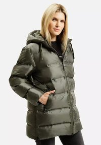 Kurtka puchowa w oliwkowym kolorze, z kapturem, zapinana na zamek z przodu oraz z kieszeniami na zamek. Materiał ma błyszczącą powierzchnię z pikowanym wzorem i miękką teksturą.