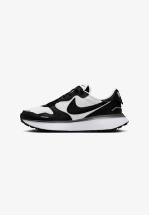Zapatillas Nike en blanco y negro con una parte superior de cuero texturizado, cuello acolchado y una entresuela blanca que presenta una suela de goma negra.