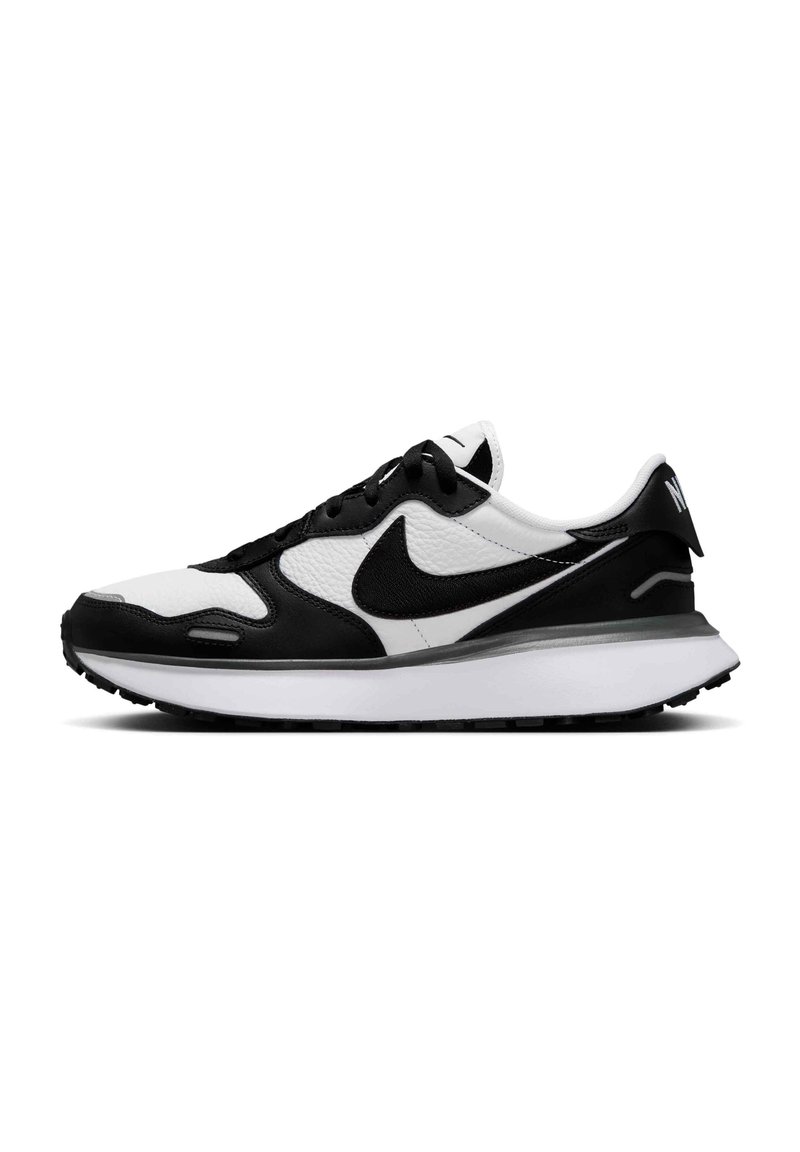 Črne in bele Nike superge s teksturirano usnjeno zgornjico, podložnim ovratnikom in belo srednji podplatom, ki ima črn gumijast podplat.