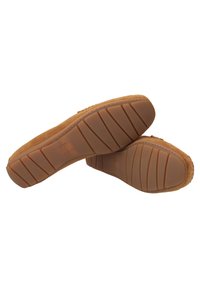 Tan suede instappers met een chunky rubberen zool die een gestructureerd patroon heeft voor grip. Stiksels langs de randen.