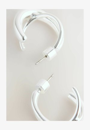 Strieborné kovové náušnice s krúžkovým tvarom a prekrúteným dizajnom, so lesklým povrchom a cylindrickým uzáverom. Hladká textura, moderný tvar.