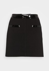 Jupe trapèze noire avec ceinture noire brillante et bordure assortie sur deux poches avant, détail de couture centrale avant.