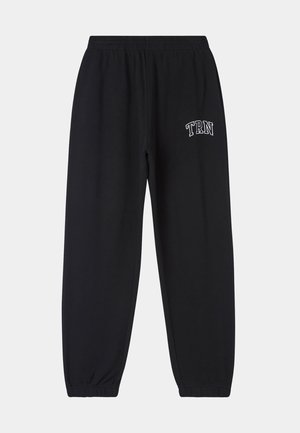 Pantaloni della tuta neri in misto cotone, con cintura elastica, polsini alle caviglie e ricamo bianco "TRN" sulla coscia sinistra.