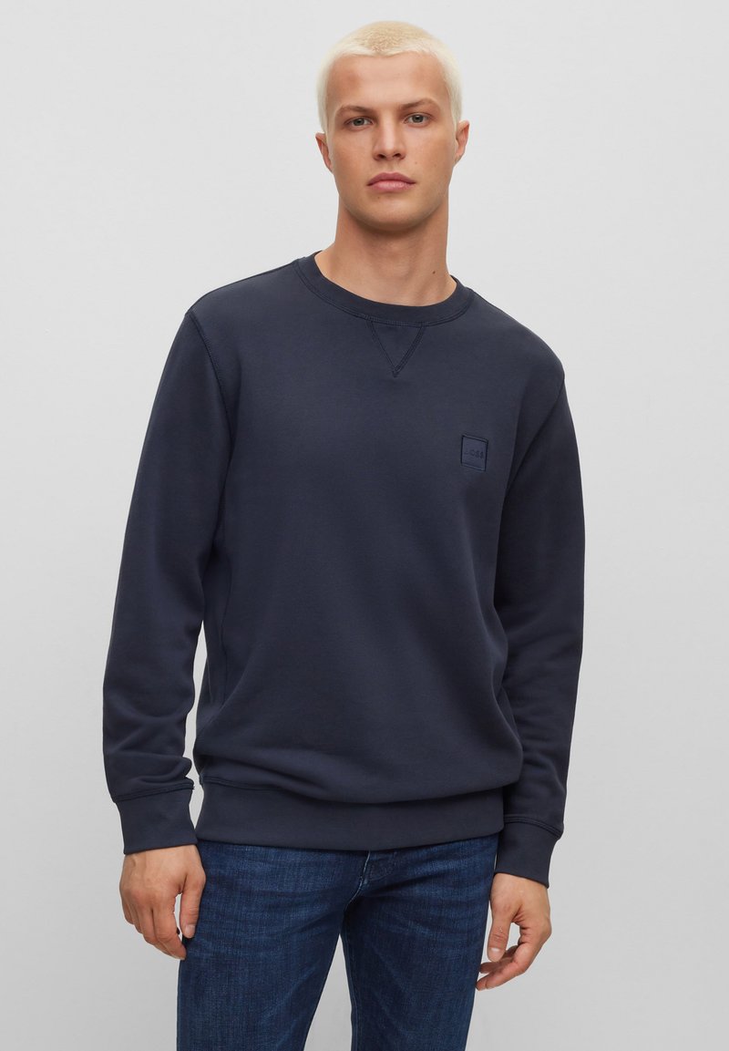 Marineblauwe sweatshirt met een ronde hals, ribgebreide manchetten en zoom. Voorzien van een klein, geëmbosseerd logo op de borst. Gemaakt van zachte, gestructureerde stof.
