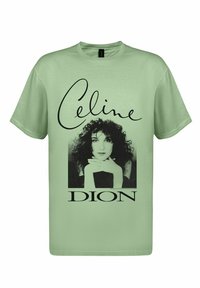 Světle zelené bavlněné tričko s černobílou grafikou ženy s kudrnatými vlasy a textem "Celine Dion" tučnými písmeny.