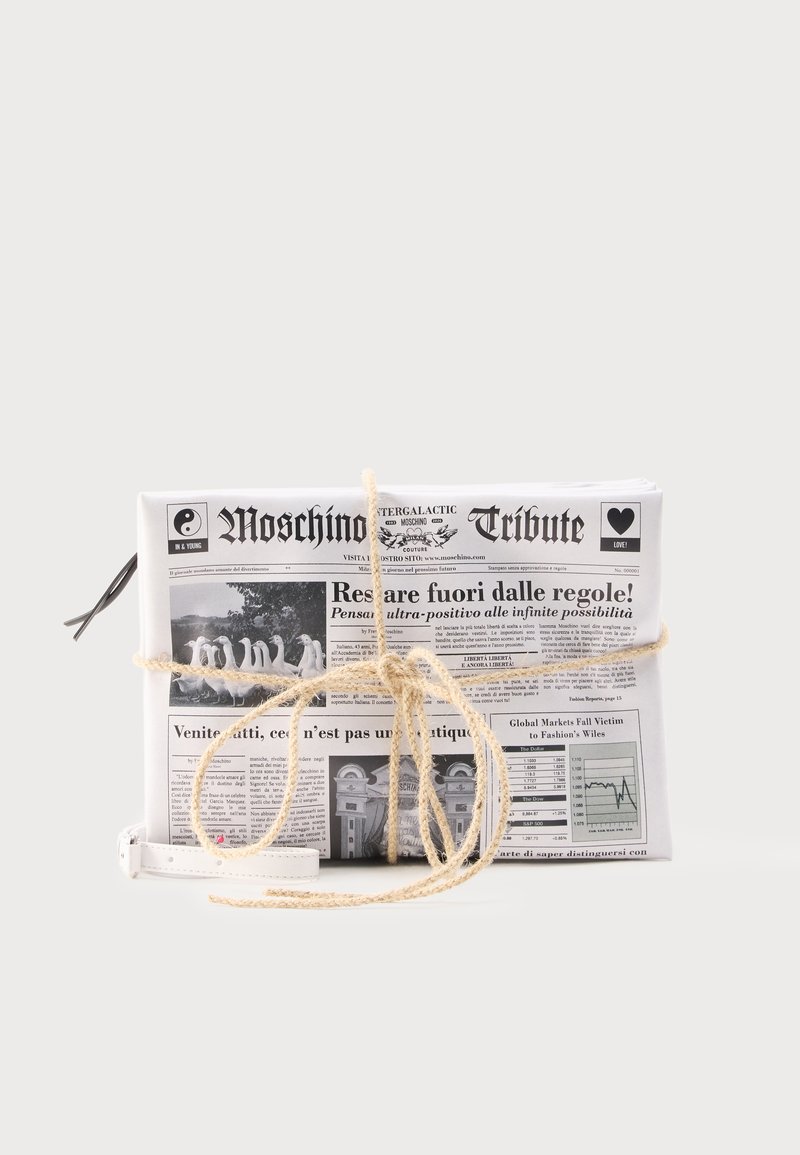 Λευκή τσάντα clutch σχεδιασμένη σαν διπλωμένη εφημερίδα με μαύρο κείμενο και εικόνες, δεμένη με μπεζ φιόγκο από σχοινί και λουράκι χειρός σε λευκό χρώμα.