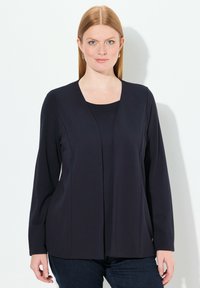 Langarm, marineblauw top met een ronde halslijn. Glad, rekbaar materiaal met een gedrapeerd voorontwerp. Combineer met jeans voor een casual look.