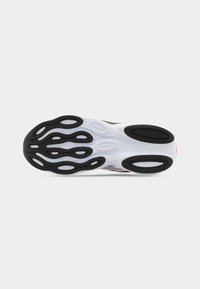 Semelle de chaussure de sport avec des motifs d'adhérence en caoutchouc noir et blanc, une semelle intermédiaire blanche et des zones de traction texturées pour la course ou l'entraînement.