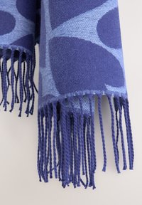 Sciarpa in lana con una combinazione di motivi geometrici blu scuro e chiaro. Rifinita con lunghe frange intrecciate ai bordi.