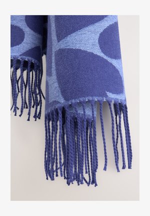 Wollen sjaal met een mix van donkere en lichte blauwe geometrische patronen. Afgewerkt met lange gedraaide franjes aan de randen.