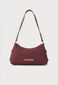 Burgundy Love Moschino shoulder bag with gold zipper and logo, curved top edge, and single strap on plain background.