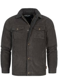 Corduroy jas in donkergrijs met een sherpa-kragen, twee borstzakken en details van messing. Voorzien van een ritsafsluiting en geribbelde manchetten.