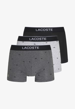Kolm paari Lacoste bokserpükse: mustad, hallid väikeste logodega ja heledat halli, millel on elastsed vööd, millel on "LACOSTE" kiri.