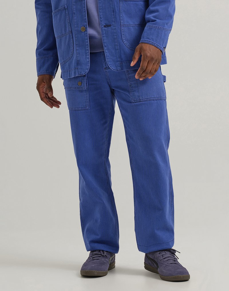 Blue corduroy jacket and pants with visible stitching, two front pockets, and a relaxed fit. Shoes are dark purple with a lace closure.