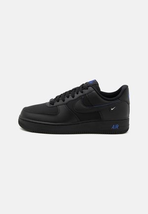 Sort lavfodret sneaker med sorte snørebånd, blå "AIR" tekst på sålen og små hvide og blå Nike-logoer på siden og hælen.