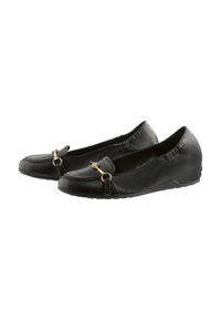 Black leather flats featuring a circular gold hardware accent, rounded toe, elasticized collar, and textured sole with grip detail.