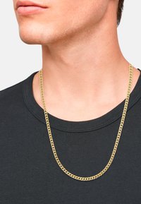 Collar de cadena en tono dorado con un dise�ño plano y retorcido, descansando sobre una camiseta de cuello redondo negra. Acabado limpio y pulido.