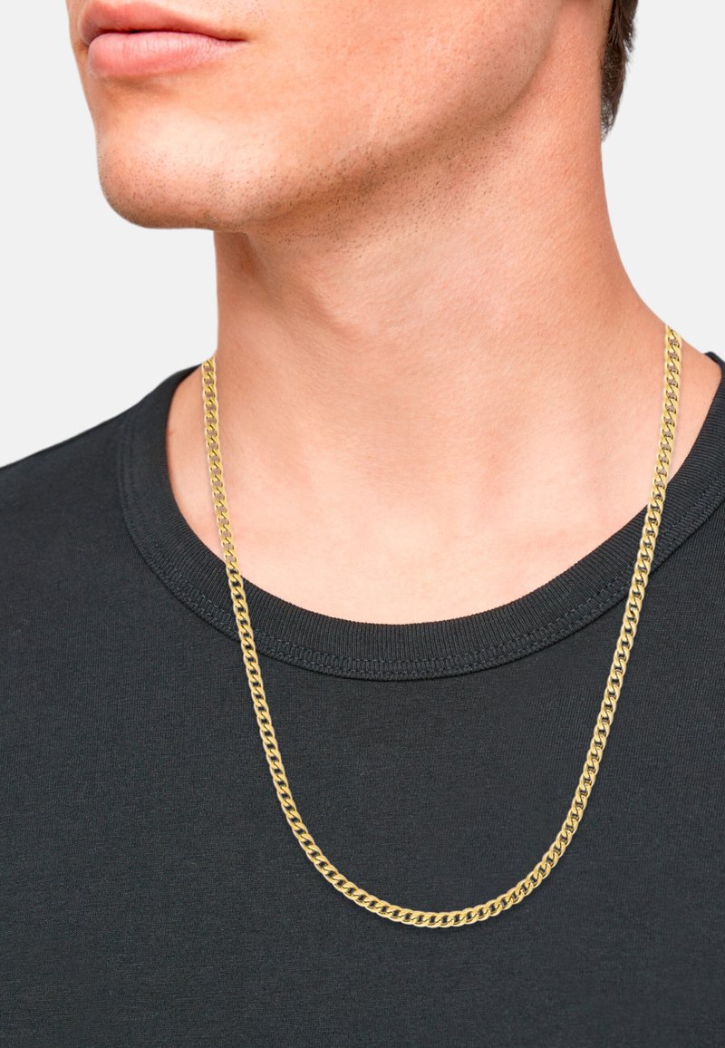 Collar de cadena en tono dorado con un diseño plano y retorcido, descansando sobre una camiseta de cuello redondo negra. Acabado limpio y pulido.