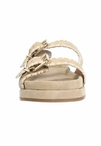 Beige sandalen met twee gevlochten banden en gouden hardware. Zachte suede textuur met een vlakke, brede zool en een ronde teenpartij.
