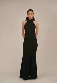 Vestido de evening preto, com alças halter, corpo justo e saia longa, apresentando uma fenda frontal e um tecido liso e texturizado.