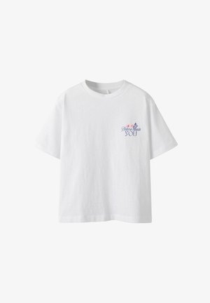 Camiseta blanca de algodón con mangas cortas y escote redondeado. En el frente presenta un texto colorido con acentos florales que dice "La naturaleza te necesita a TI."