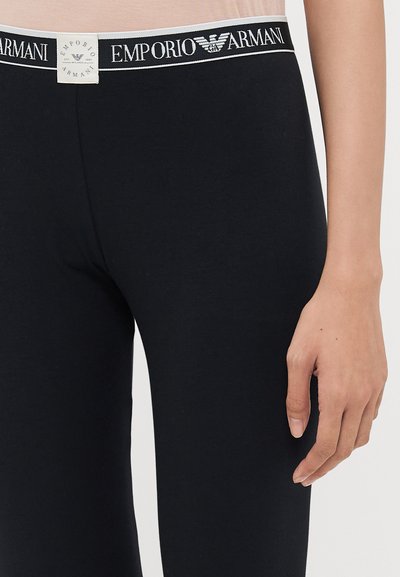 Svarta leggings med en slät textur, med ett märkes-elastiskt midjeband i svart och vitt med "Emporio Armani"-logotyp.
