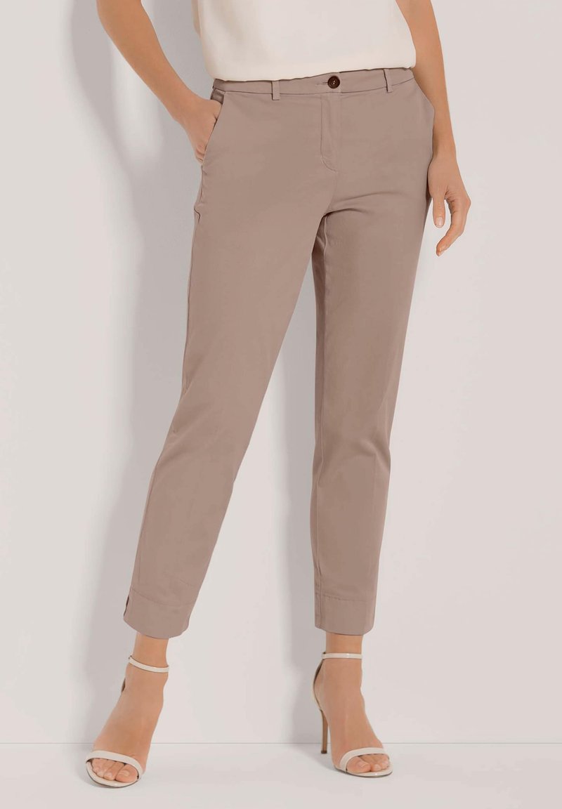 Beige op maat gemaakte broeken met een slim fit, voorzien van zijzakken, een knoopsluiting en opgerolde manchet. Gemaakt van gladde stof.