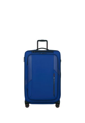 Blue upright suitcase with telescopic handle, front zipper pocket, and four black wheels with red accents on a white background.