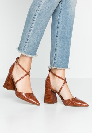 Bruine schoenen met hak van imitatieleer, voorzien van een puntige neus en een textuur met krokodillenpatroon, met een kruisbandontwerp en blokhak.